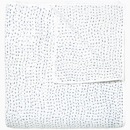 A white Organic Hand Stitched Light Indigo Quilt with blue dots on it, made with hand stitching and cotton voile, by John Robshaw.