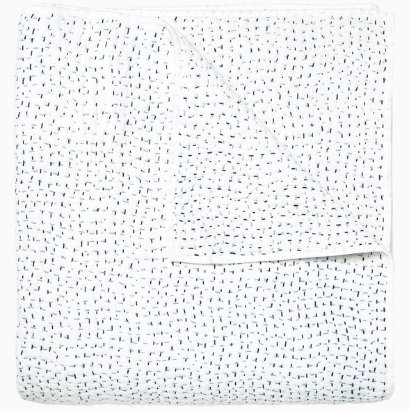 A white Organic Hand Stitched Light Indigo Quilt with blue dots on it, made with hand stitching and cotton voile, by John Robshaw.