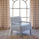 The Square Chair in Marmar Marigold and Natesh Sand by John Robshaw, upholstered in a vibrant performance fabric, sits on a tiled floor in front of a tall arched window with patterned curtains.