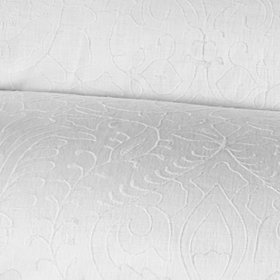 Close-up image of the Amina Ecru Duvet Set by John Robshaw, showcasing a white fabric with an intricate, embossed floral pattern, crafted from the finest quality cotton linen.
