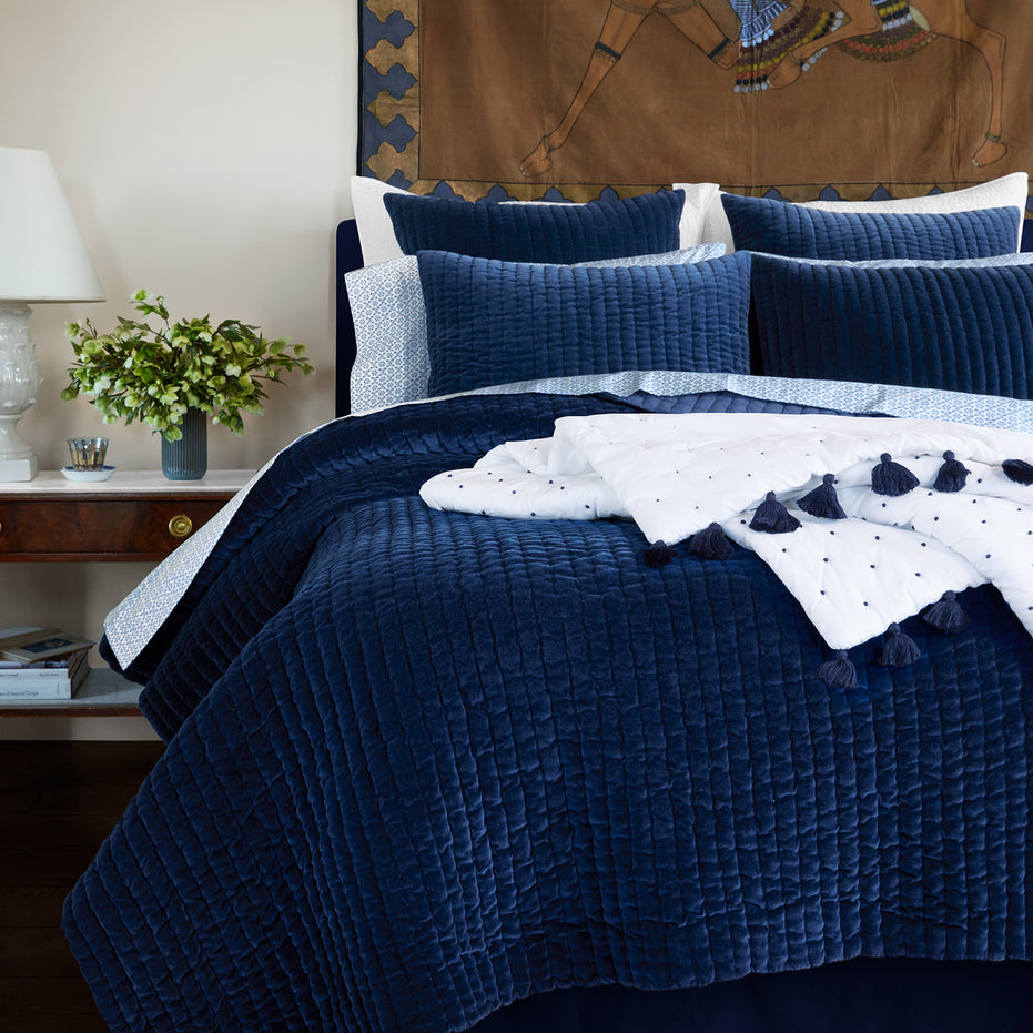 A John Robshaw velvet bed with hand quilted Velvet Indigo Quilt comforter and pillows, made by Indian artisans.