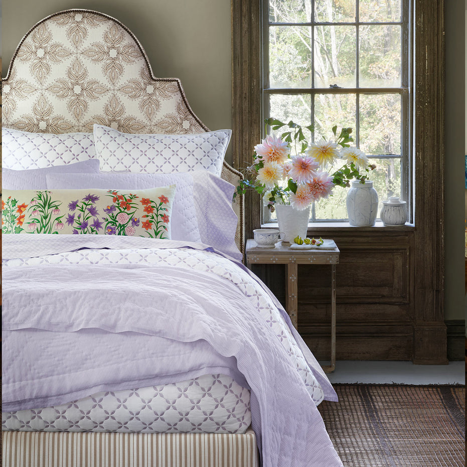 A bedroom with a John Robshaw Nandi Lavender Quilt bed and pillows.