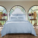 A cotton voile bed with a Nandi Light Indigo Quilt by John Robshaw and arched windows.