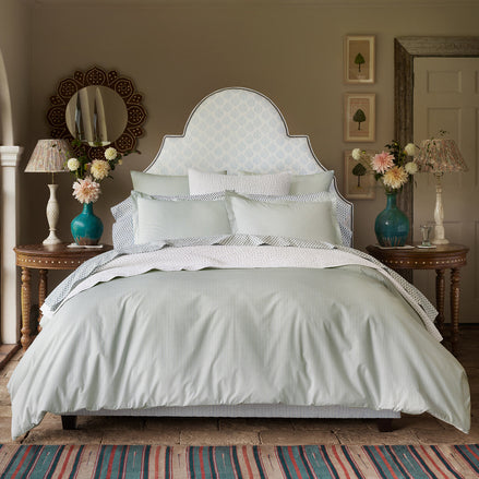 A bedroom with a Cinde Sage Organic Duvet made of organic long staple cotton, designed by John Robshaw.