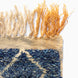 Corner of a Blue Village Wool Rug in textured blue, cream, and yellow wool with long, fringed edges.