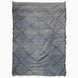 John Robshaw Big Zanafi Wool Rug, a handwoven rectangular rug featuring a blue and white diamond pattern and fringed edges, inspired by traditional Berber designs.