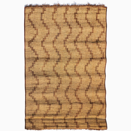 Rectangular John Robshaw Tifnout Tuareg mat woven from fibers with a brown zigzag pattern and fringed ends.