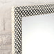 Close-up of the Arohi Bone Inlay Mirror by John Robshaw, featuring a rectangular diamond pattern with a black and white geometric frame, mounted on a white textured brick wall.