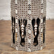 The Karigar Table by John Robshaw is an octagonal wooden piece, handcrafted from Indian hardwood and adorned with intricate geometric inlay patterns and elegant arched cutouts. Displayed on a parquet floor against a white textured wall, this bone inlay furniture showcases exceptional artisanal craftsmanship.