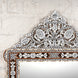 Presenting the Ila Bone Inlay Mirror by John Robshaw—an elegant statement piece featuring intricate geometric and floral inlay work on a hand-carved frame, beautifully set against a white textured brick wall.