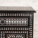 Close-up of the Ahan Bone Inlay Cabinet by John Robshaw, showcasing intricate white geometric patterns on its drawers and surface, set against a light-colored background.
