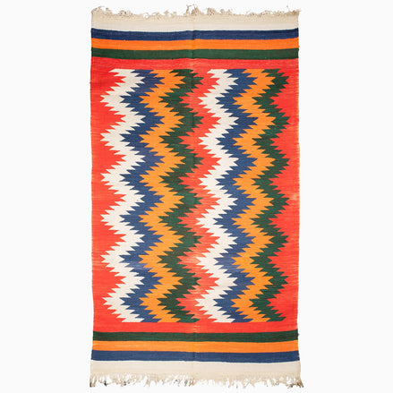 A vintage Zag Zig Rug by John Robshaw with red, blue, and orange stripes, sourced from Punjab weaving center.