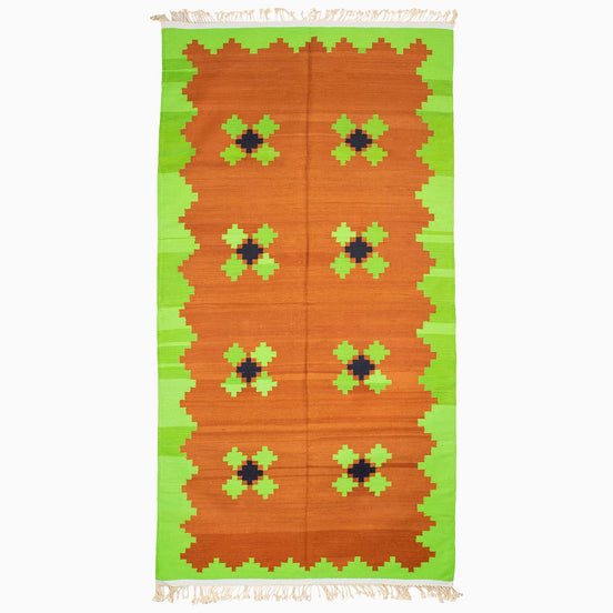 A Lime and Tea Rug in orange and green with a geometric pattern, handcrafted by the John Robshaw weaving center.