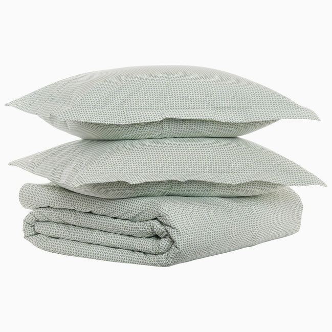 A stack of John Robshaw's Cinde Sage Organic Duvet pillows on top of each other.