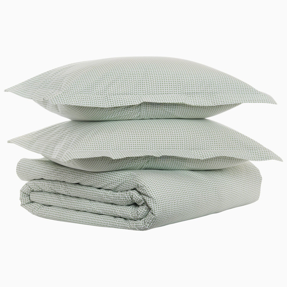A stack of John Robshaw's Cinde Sage Organic Duvet pillows on top of each other.