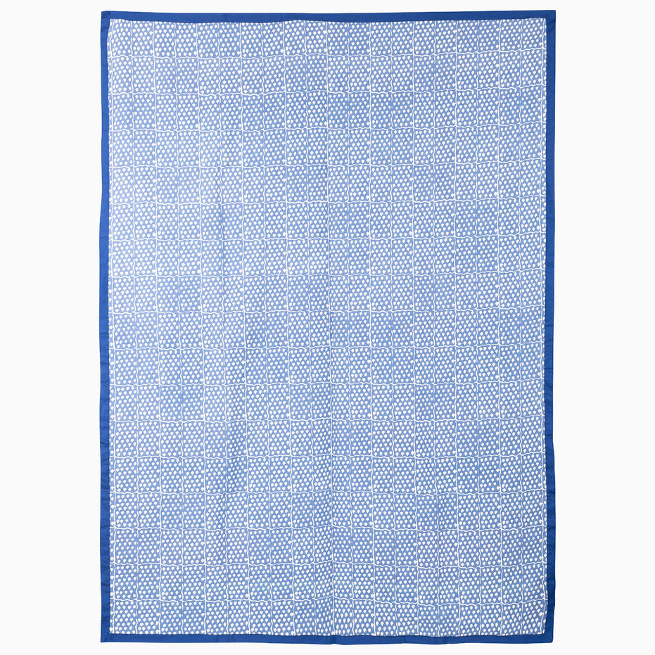 John Robshaw Indigo Sky Suzani Blanket in a rectangular hand block printed design with a blue and white geometric grid pattern and a solid blue border.