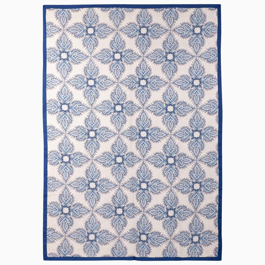 John Robshaw Open Water Suzani Blanket with a vintage pattern of blue and white floral medallions and a solid indigo border.