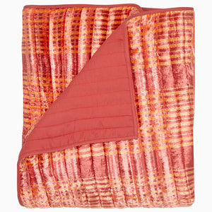 The Jatin Terracotta Throw by John Robshaw features a patterned velvet texture in pink, orange, and gold with a solid pink back, shown on a plain background.