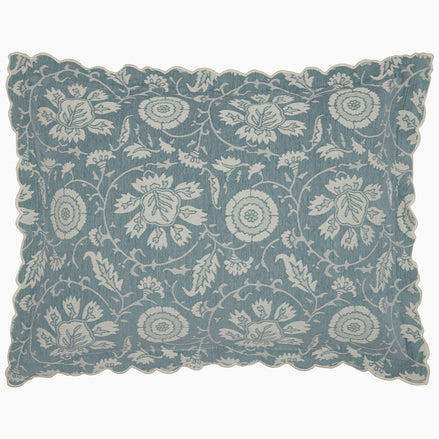 The John Robshaw Kimari Mist Coverlet showcases a blue background adorned with delicate woven florals, crafted from soft jacquard cotton chenille and finished with scalloped edges.