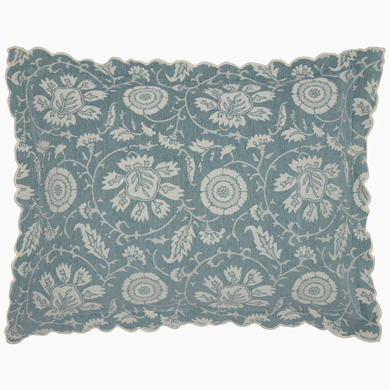 The John Robshaw Kimari Mist Coverlet showcases a blue background adorned with delicate woven florals, crafted from soft jacquard cotton chenille and finished with scalloped edges.