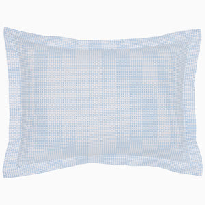 The Cinde Light Indigo Organic Duvet by John Robshaw is a rectangular pillow with a light blue and white patterned cover, featuring a 200 thread count percale with small repeated designs and a flanged edge.