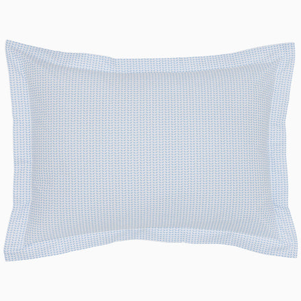 The Cinde Light Indigo Organic Duvet by John Robshaw is a rectangular pillow with a light blue and white patterned cover, featuring a 200 thread count percale with small repeated designs and a flanged edge.