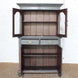The Revati Wooden Cabinet by John Robshaw showcases arched glass doors, two drawers, and lower cabinet doors that open to reveal spacious empty shelves inside.