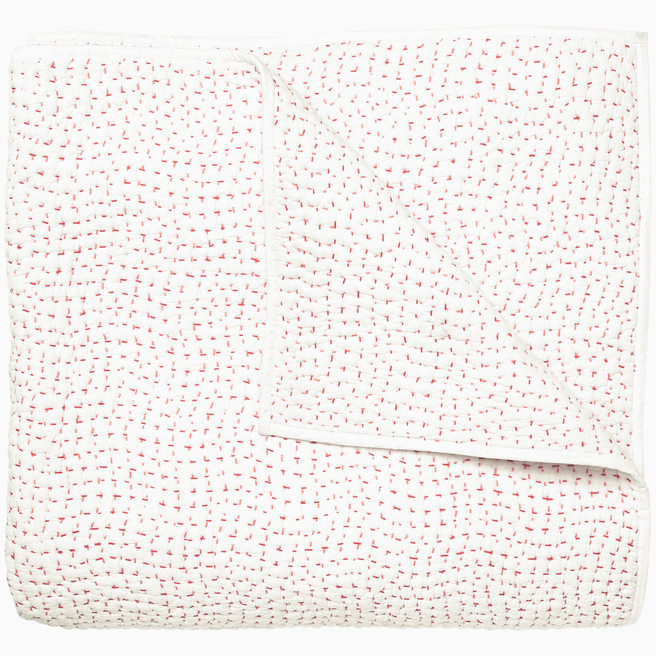 A white and pink Organic Hand Stitched Lotus Quilt with dots, by John Robshaw.