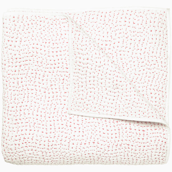 A white and pink Organic Hand Stitched Lotus Quilt with dots, by John Robshaw.