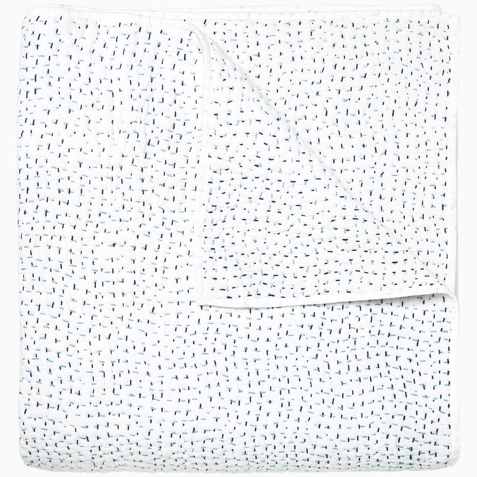 A white Organic Hand Stitched Light Indigo Quilt with blue dots on it, made with hand stitching and cotton voile, by John Robshaw.