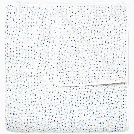 A white Organic Hand Stitched Light Indigo Quilt with blue dots on it, made with hand stitching and cotton voile, by John Robshaw.