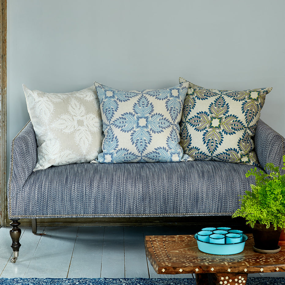 A Verdin Euro couch with blue pillows and a potted plant made of cotton linen blend fabric.