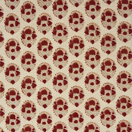 A red and beige floral pattern, created using traditional craftsmanship using the Kukkuta Teak Fabric by John Robshaw.