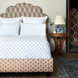 A bed with a Layla Azure Quilt headboard made of cotton voile from John Robshaw.