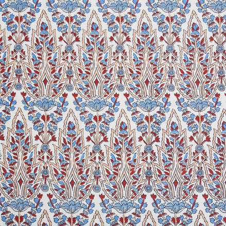 A beautiful blue and red floral pattern resembling the blooming gardens of Mughal, hand block printed on a pristine white background using the Marmar Coral Fabric by John Robshaw.