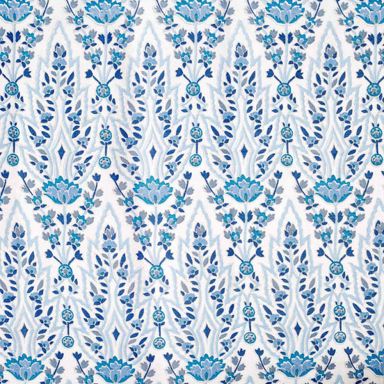 A hand block printed Marmar Turquoise Fabric with a blue and white floral pattern on a crisp white background, inspired by the stunning Mughal gardens in India, created by John Robshaw.