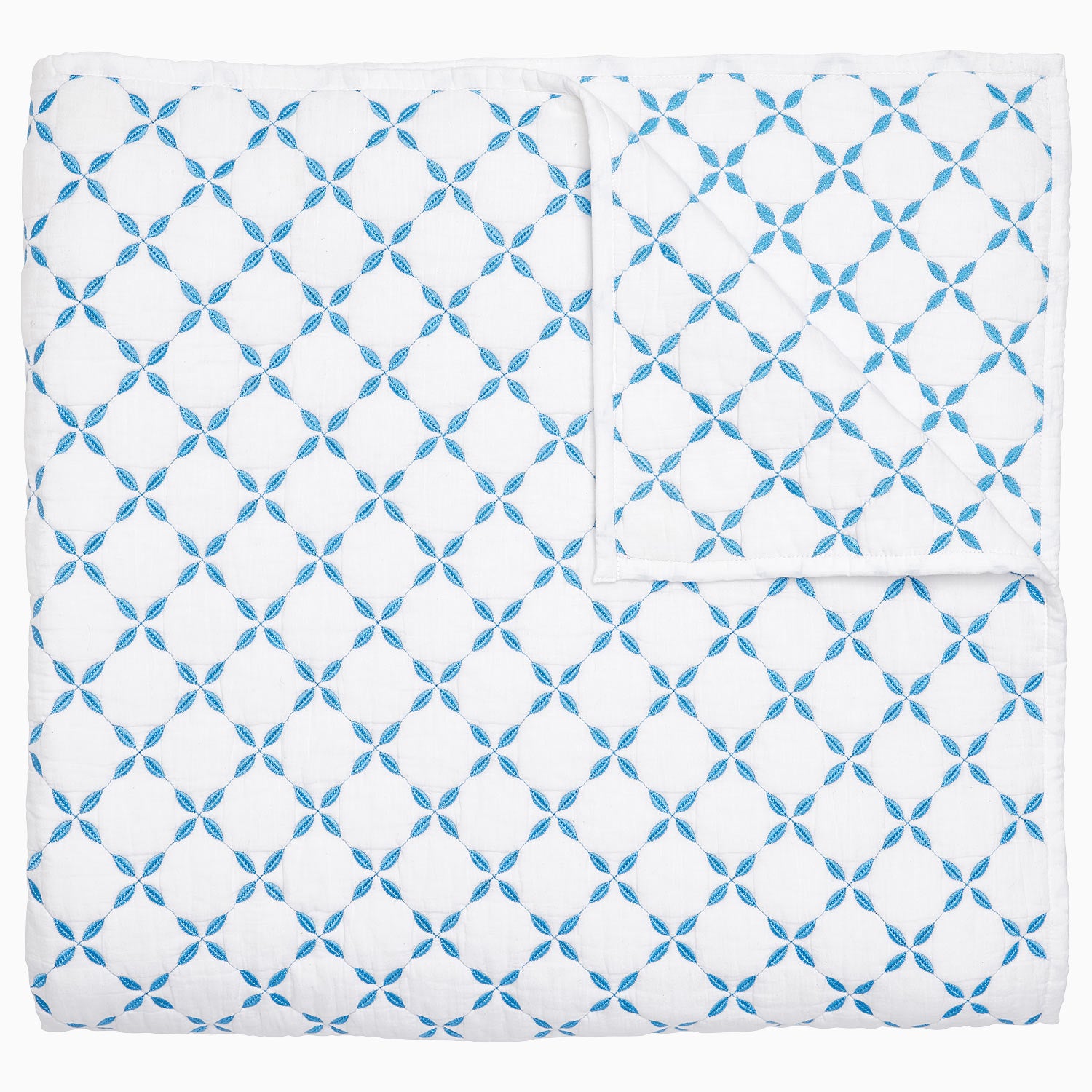 A Layla Azure Quilt by John Robshaw, a cotton voile blue and white blanket with a geometric pattern inspired by Mughal gardens.