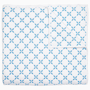 A Layla Azure Quilt by John Robshaw, a cotton voile blue and white blanket with a geometric pattern inspired by Mughal gardens.