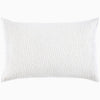 A white pillow with hand stitching and organic cotton voile coverlets, featuring the Organic Hand Stitched Sand Quilt by John Robshaw.