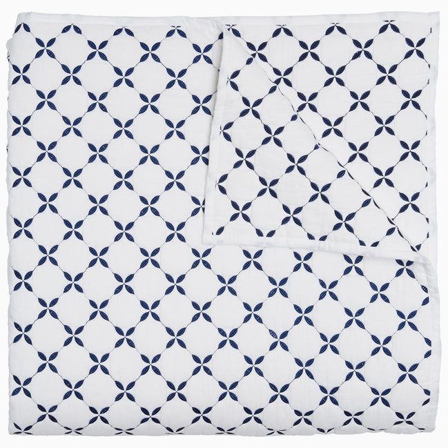 A blue and white Layla Indigo Quilt blanket with a cross design by John Robshaw.