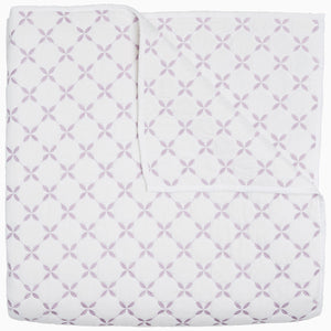 A Layla Lavender quilt by John Robshaw, made from cotton voile, with a cross pattern in white and purple, inspired by Mughal gardens.