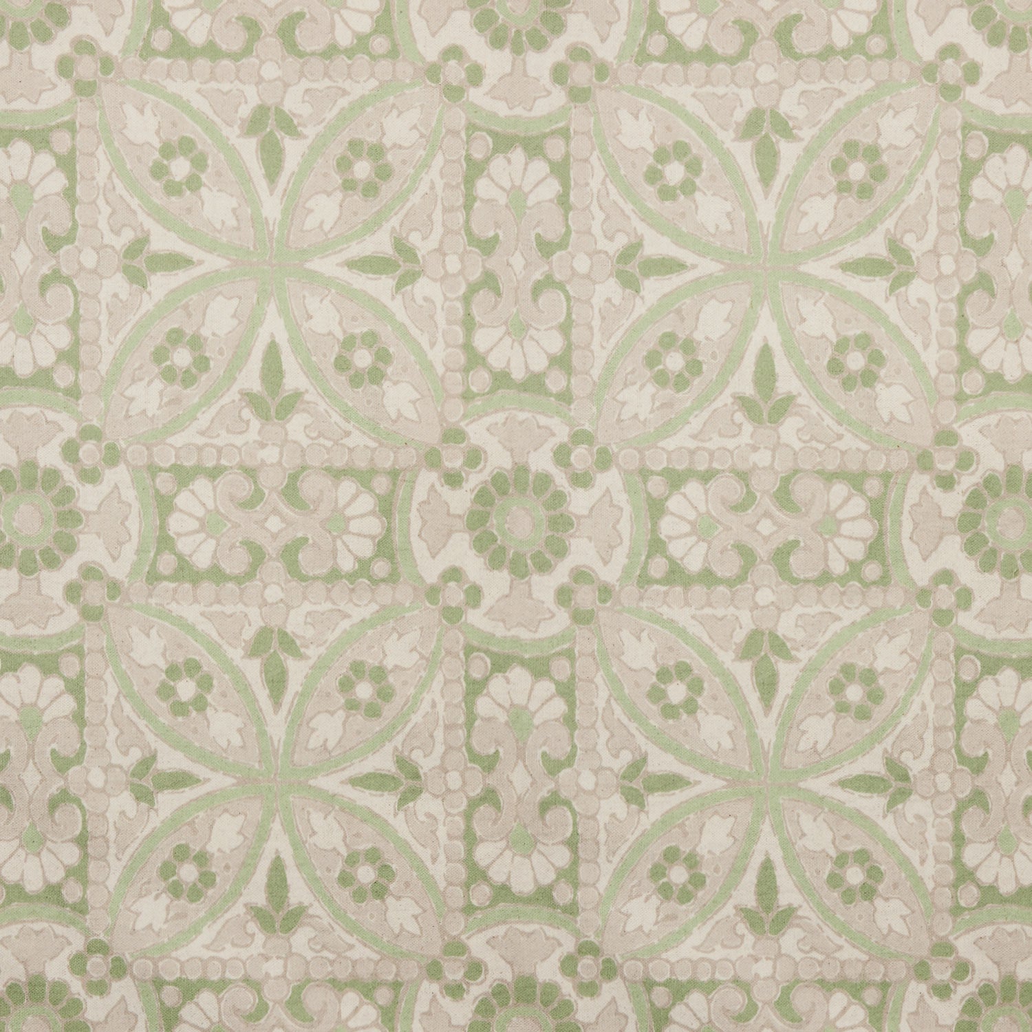 A printed green and white tile pattern with a floral design on John Robshaw's handmade Oman Sage Fabric.