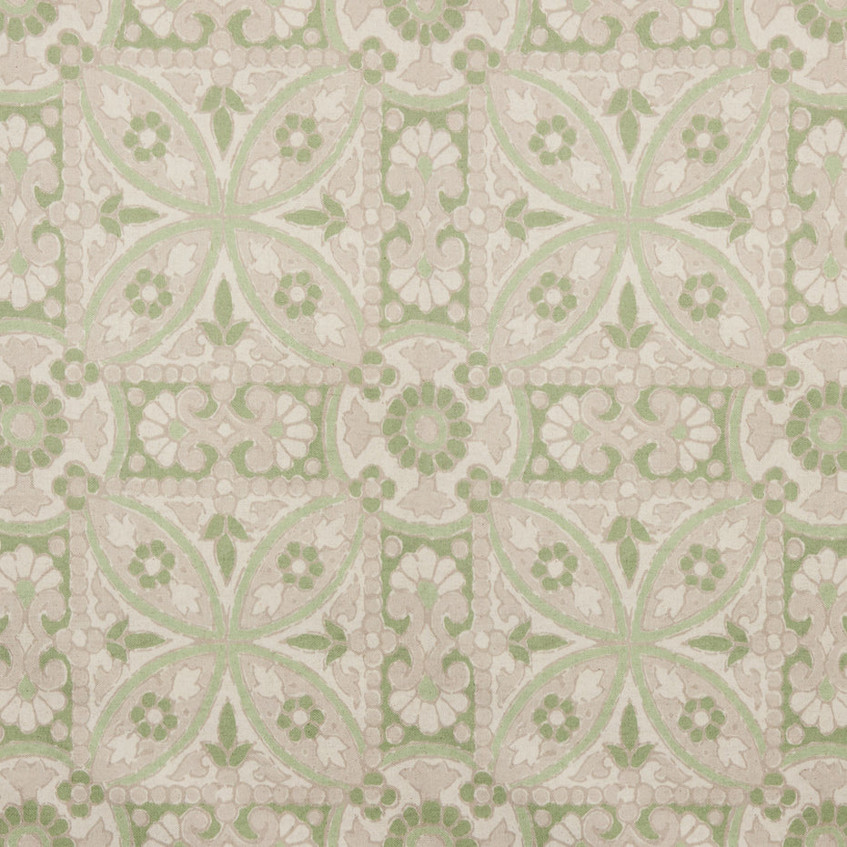 A printed green and white tile pattern with a floral design on John Robshaw's handmade Oman Sage Fabric.