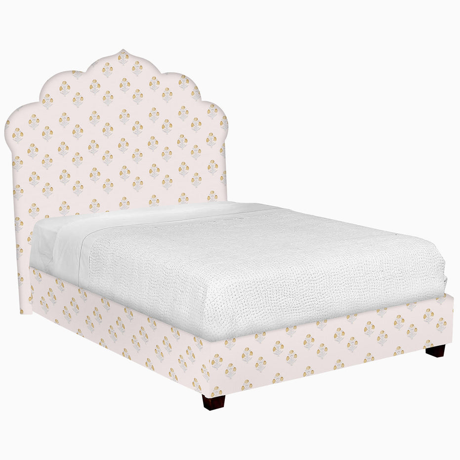 A Custom Bihar Bed by John Robshaw with a pink and gold patterned fabric headboard.