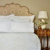 A bed with blue and white bedding and the John Robshaw Custom Bihar Headboard that can be delivered to your doorstep with white glove delivery.